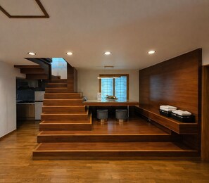 A modern interior with a wooden staircase leading to a kitchen area.