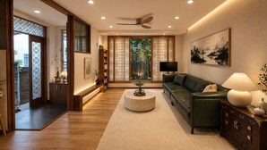 Un salon moderne avec un canapé vert, une table basse ronde et un ventilateur de plafond.
