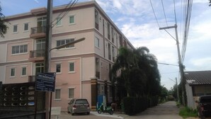 A multi-story residential building with balconies, a parked car, and a scooter. - Dariva Place (Pattaya)