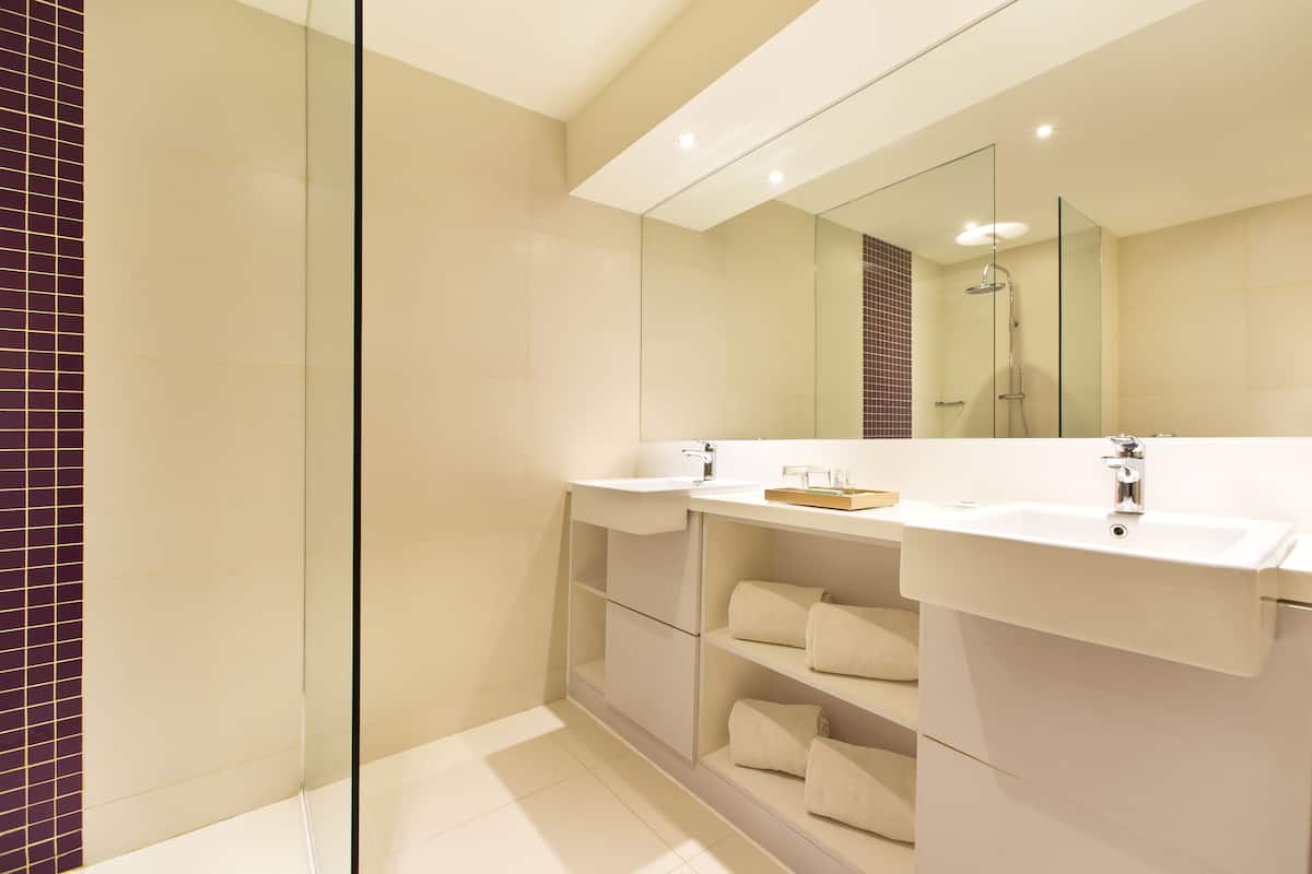 deluxe room | bathroom | shower, free toiletries, bathrobes, slippers