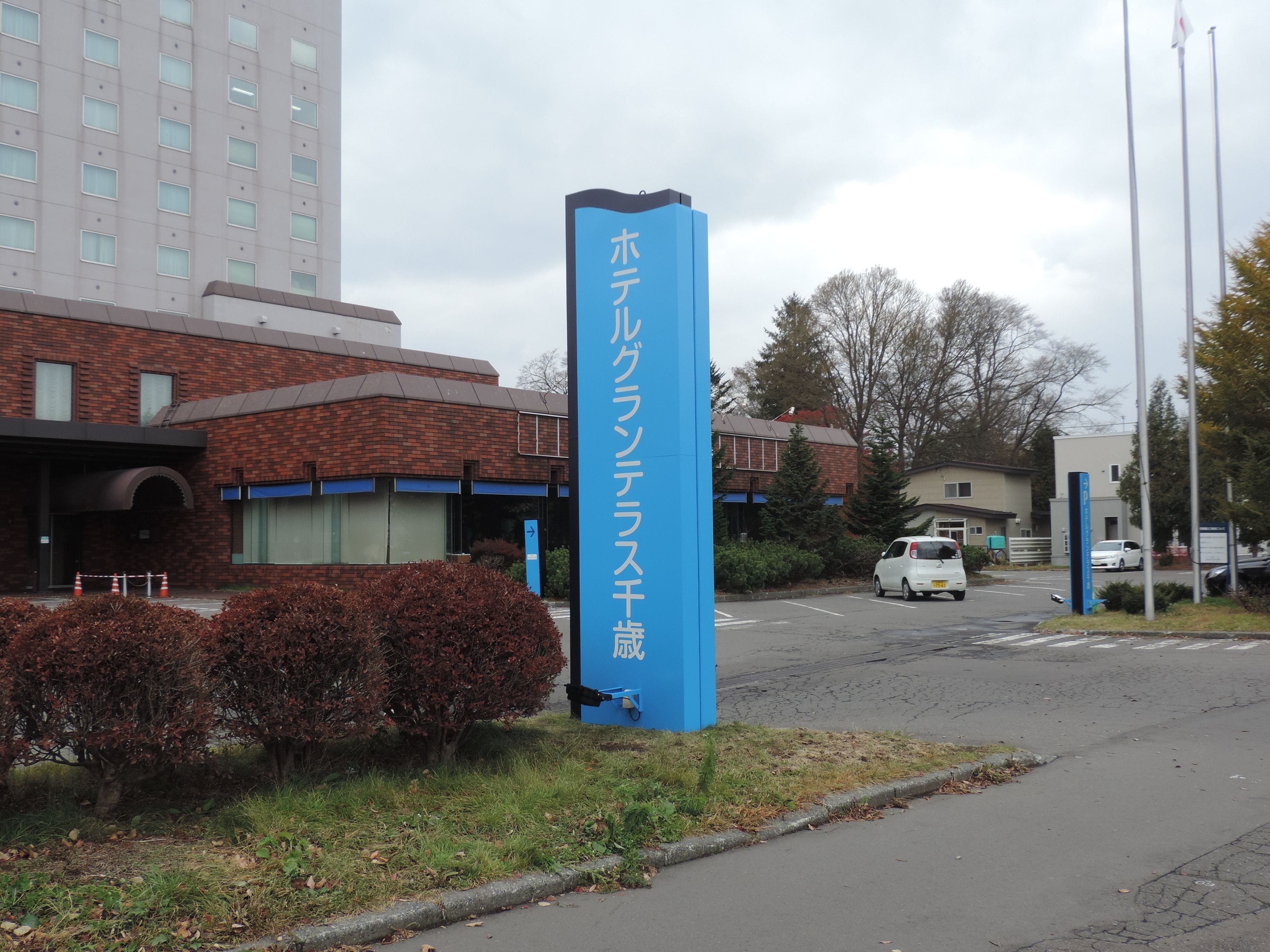 A building with a blue sign indicating a hotel.
