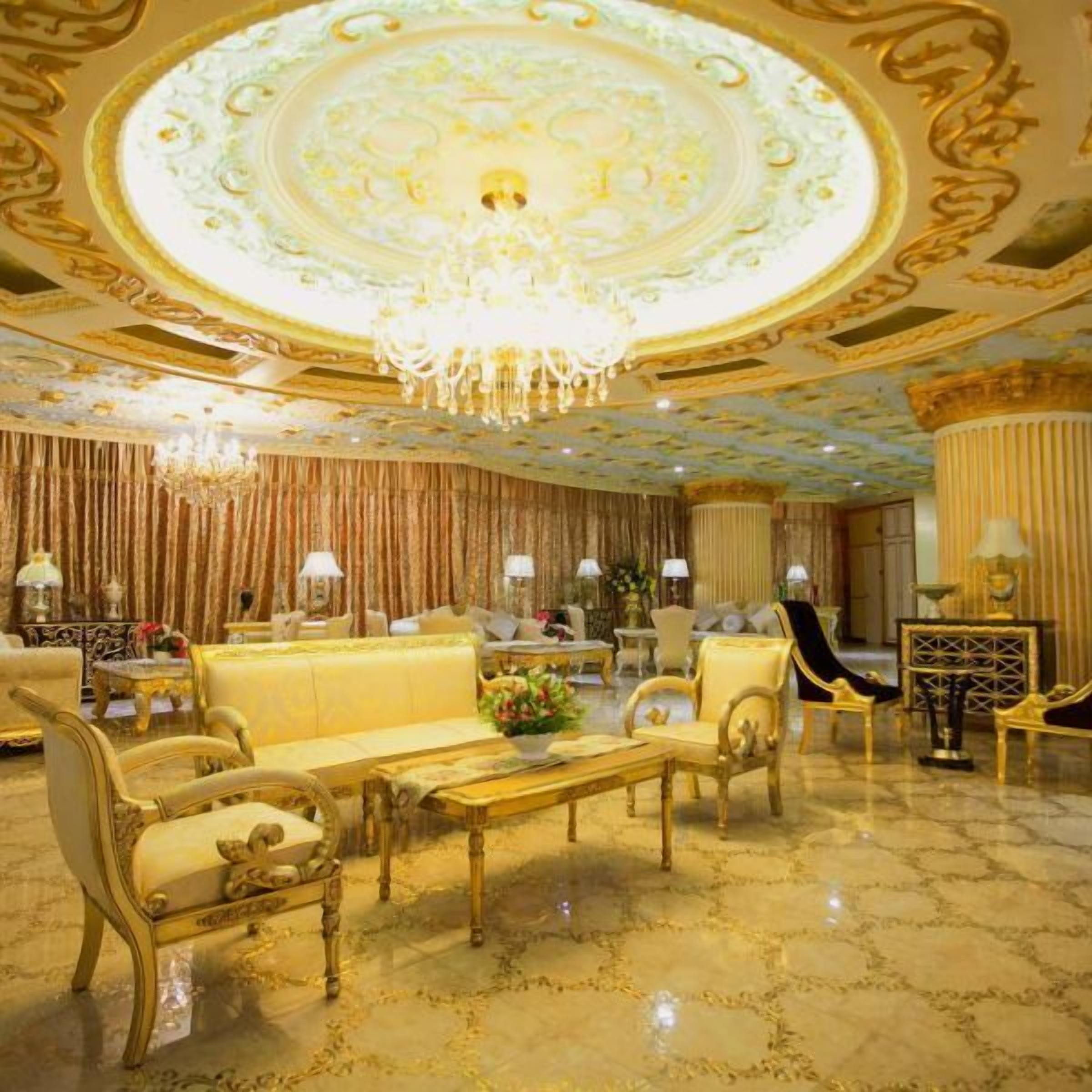 A luxurious room with ornate ceiling, chandeliers, and elegant furniture.