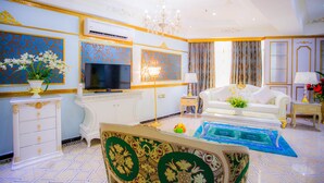 A luxurious living room with a television, sofa, decorative lamps, and a chandelier. - Lace Boutique Hotel (Johor Bahru)