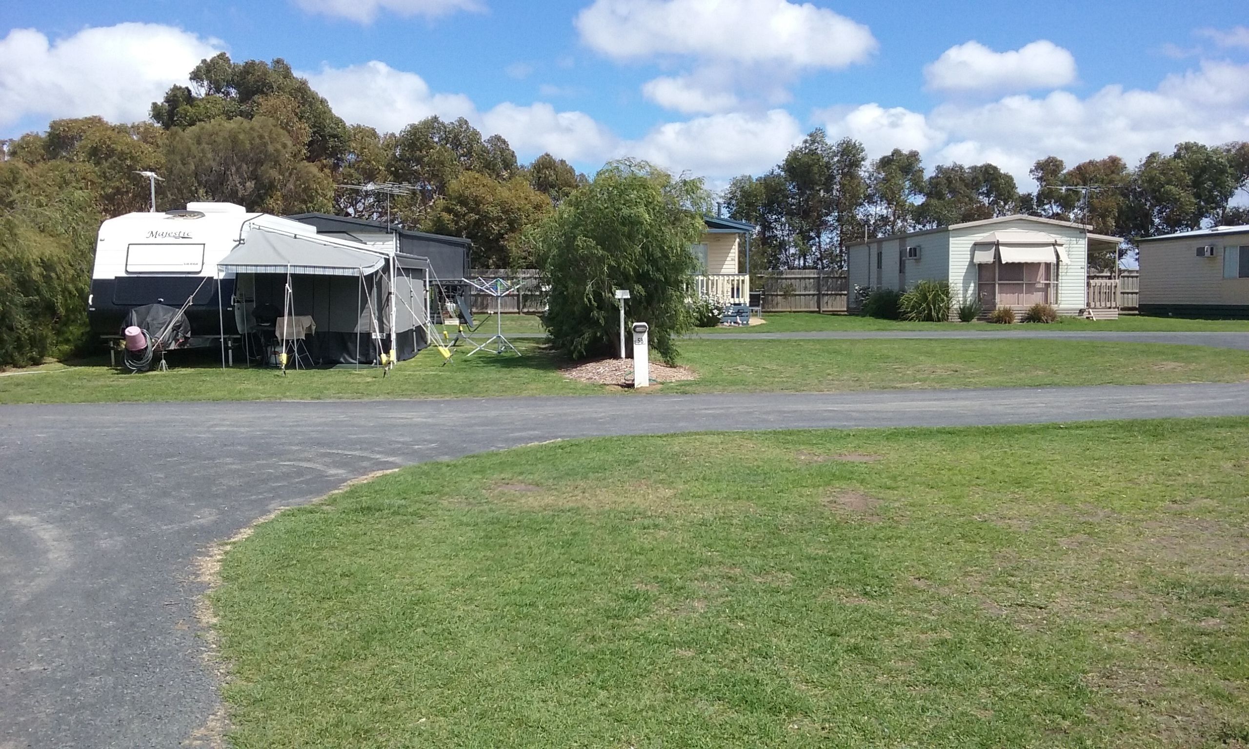 A caravan park with a caravan labeled 'Majestic' and a small house.
