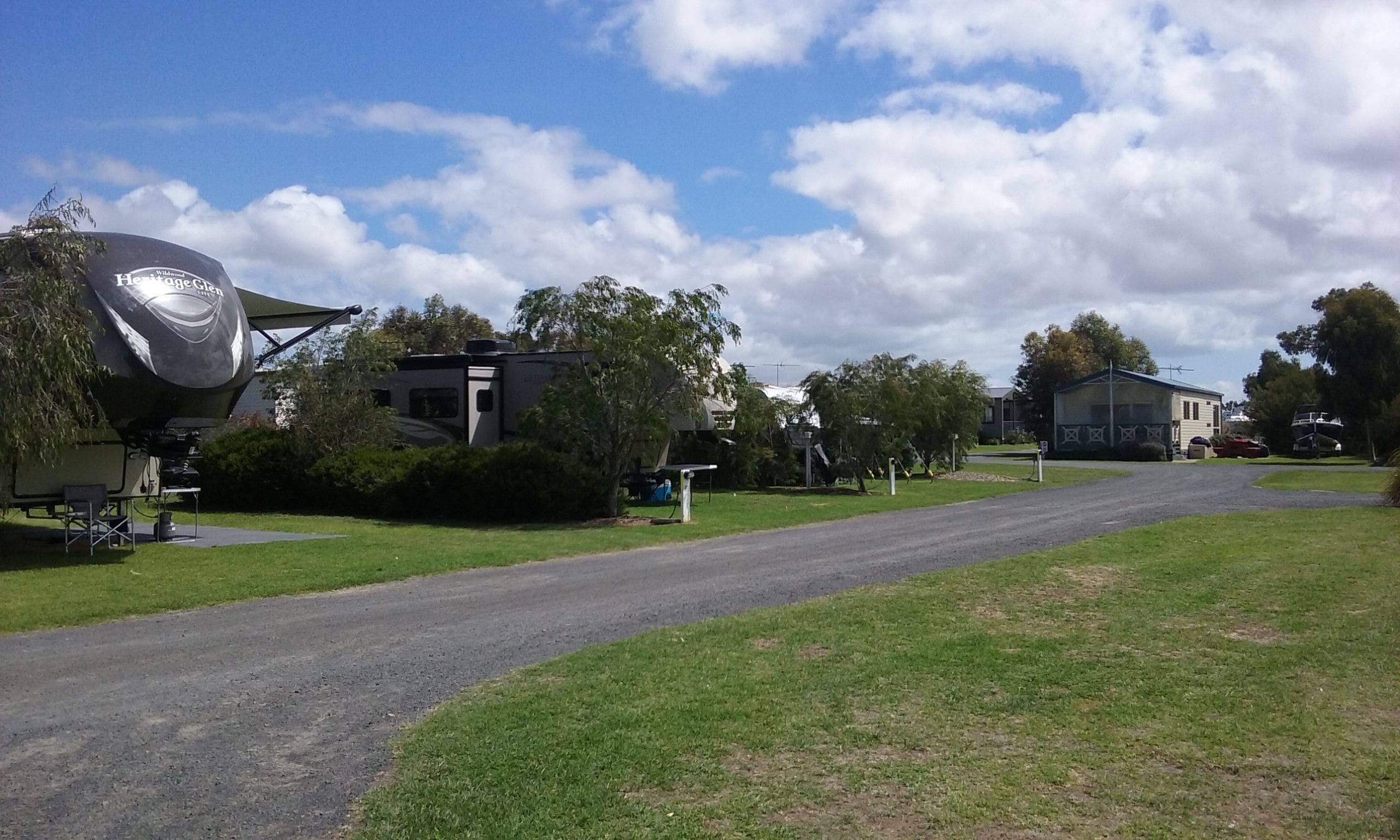 A residential area with a large satellite dish, a house, and a road.