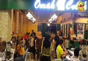 A busy restaurant interior with tables and chairs, a counter, and a visible menu board. - Crown Hotel (Mataram)