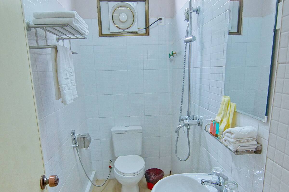 A small, clean bathroom with a toilet, sink, and shower.