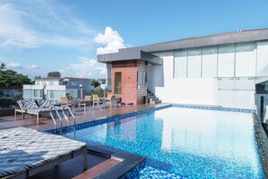 A modern hotel with a rooftop pool, lounge chairs, and a clear blue sky. - Clover Suites Royal Lake Yangon (Yangon)