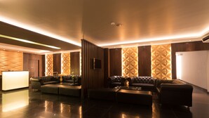 A modern lobby with a reception desk, leather seating, and geometric wall patterns. - Clover Suites Royal Lake Yangon (Yangon)