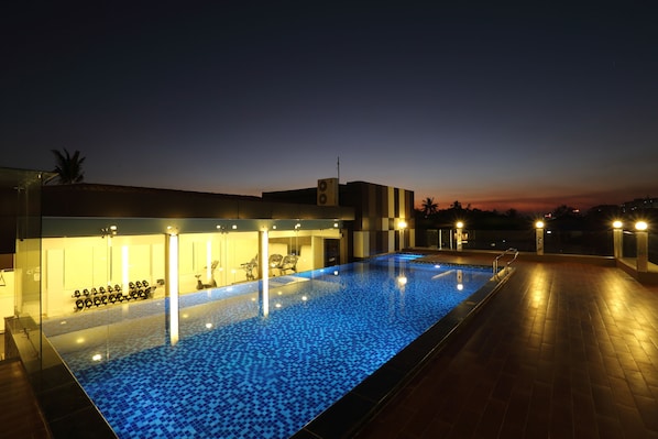 Una piscina al aire libre, sillones reclinables de piscina