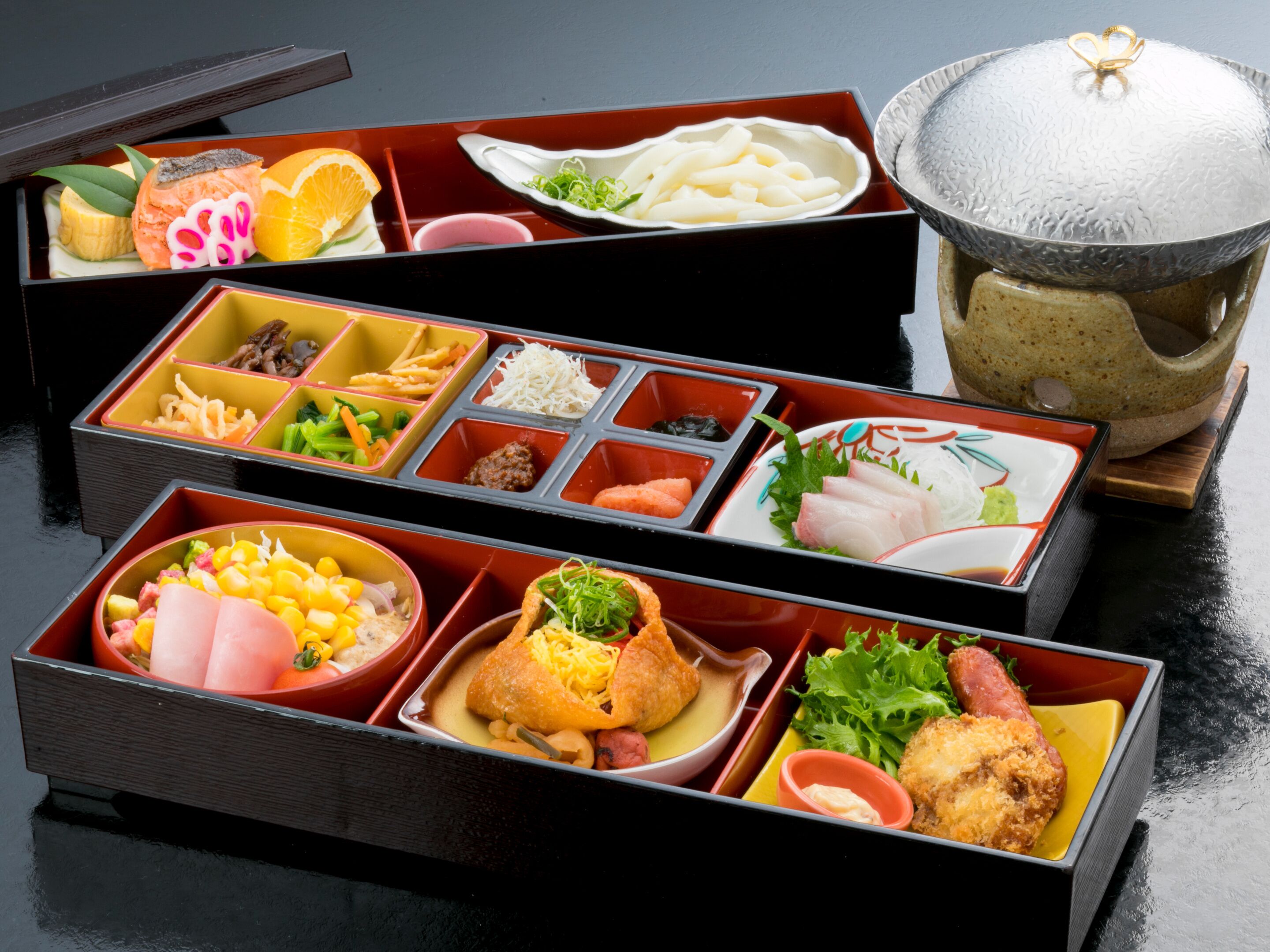Un conjunto de comida tradicional japonesa con varios platos en compartimentos separados.