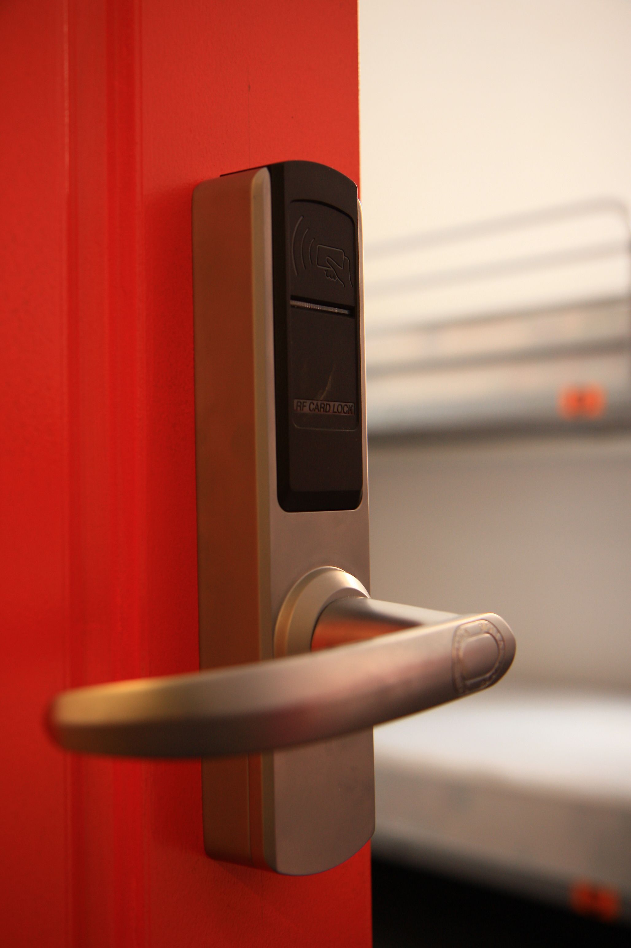 A modern door with a card reader and a keyhole, indicating a secure entry system.