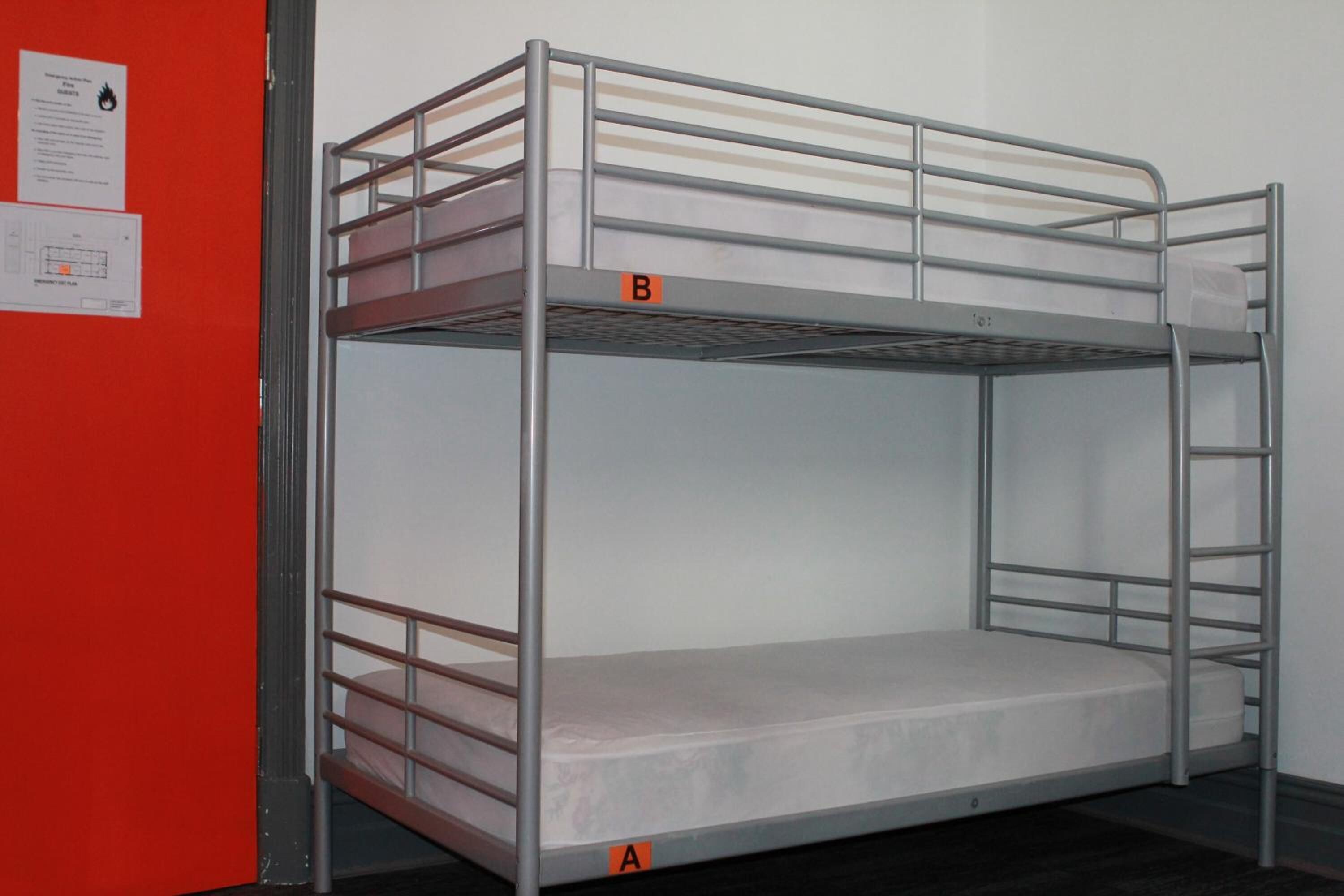 A bunk bed with a metal frame and a mattress.