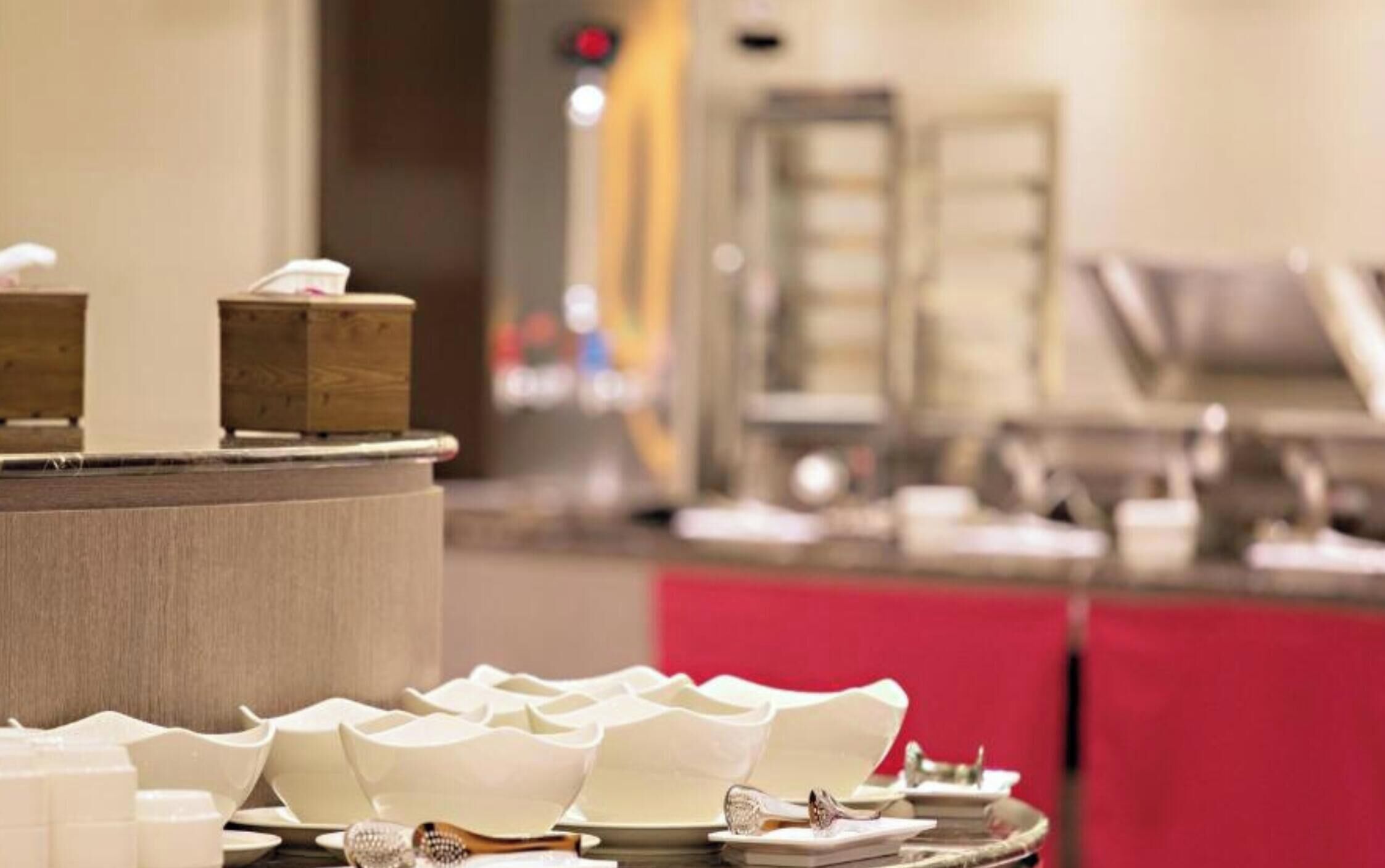 A buffet setup with various dishes and utensils.