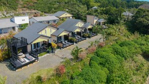 Een resort met meerdere gebouwen, buitenzitgedeeltes en een bergachtige achtergrond.