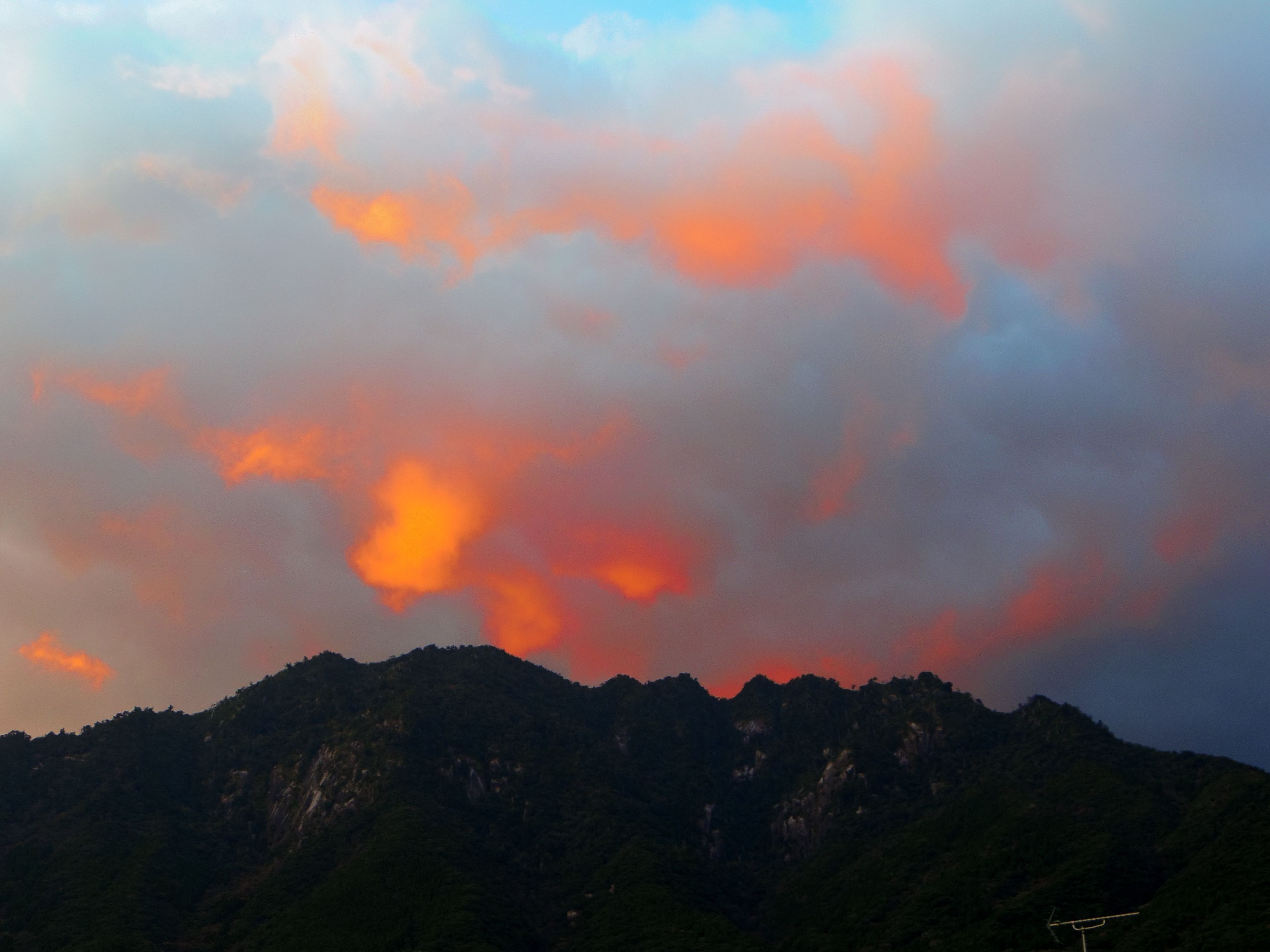 A mountain range with a cloudy sky.