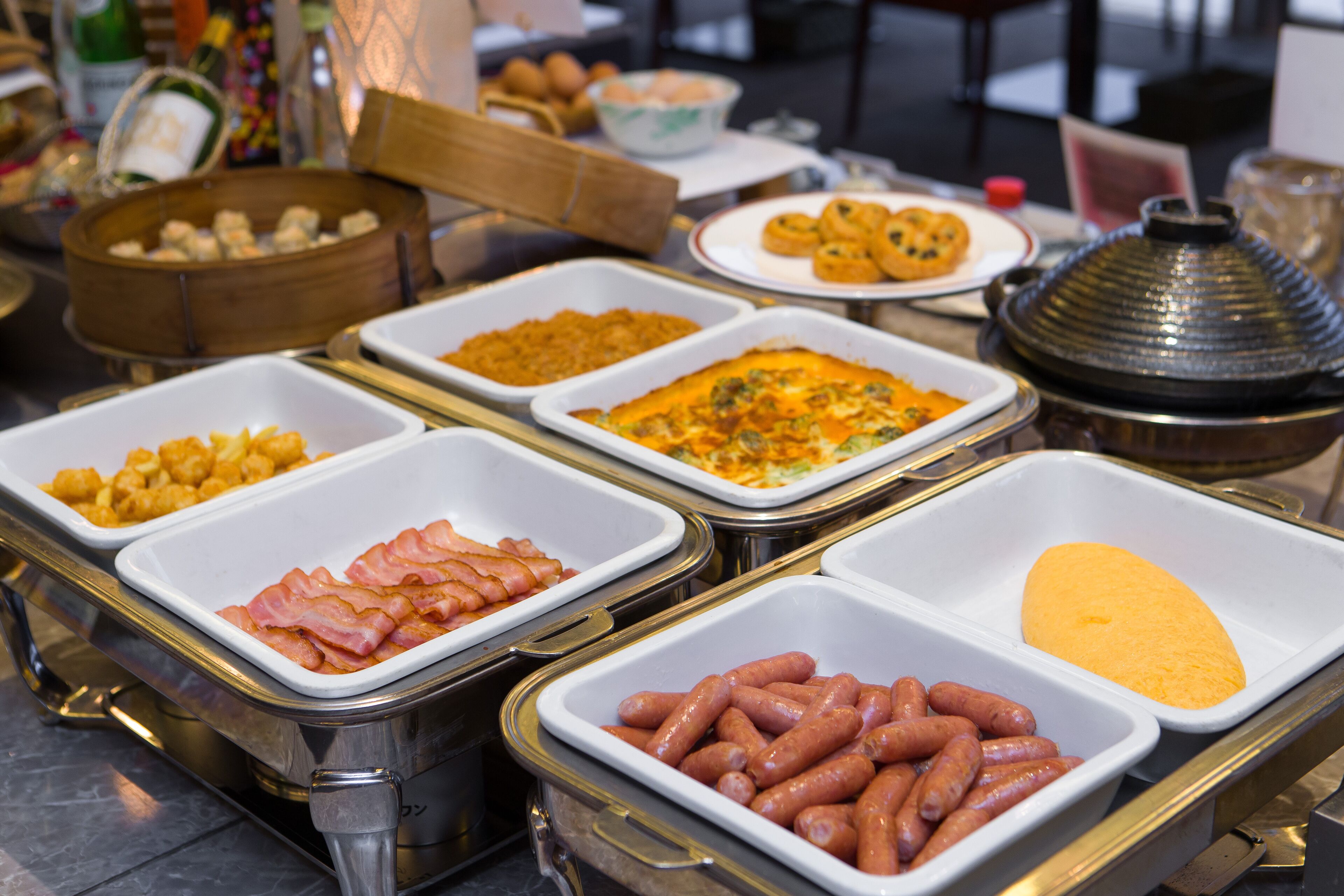 A buffet with various food options including ham, sausages, and a cheese spread.