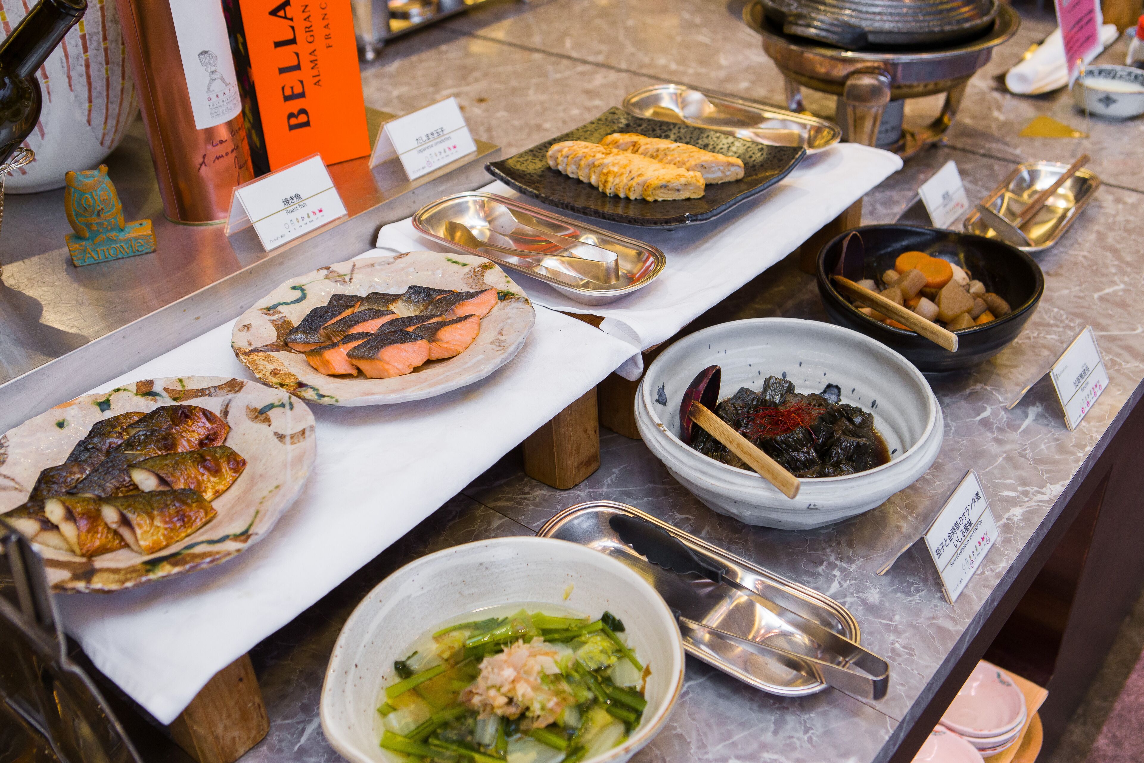 A buffet with various dishes including seafood, vegetables, and a bowl of soup.