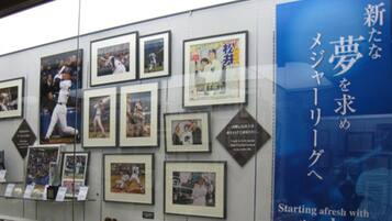 A wall with framed photographs and a large blue advertisement.