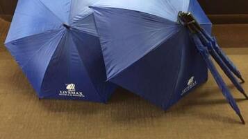 Two blue umbrellas with the LIVEMAX logo on a wooden surface.