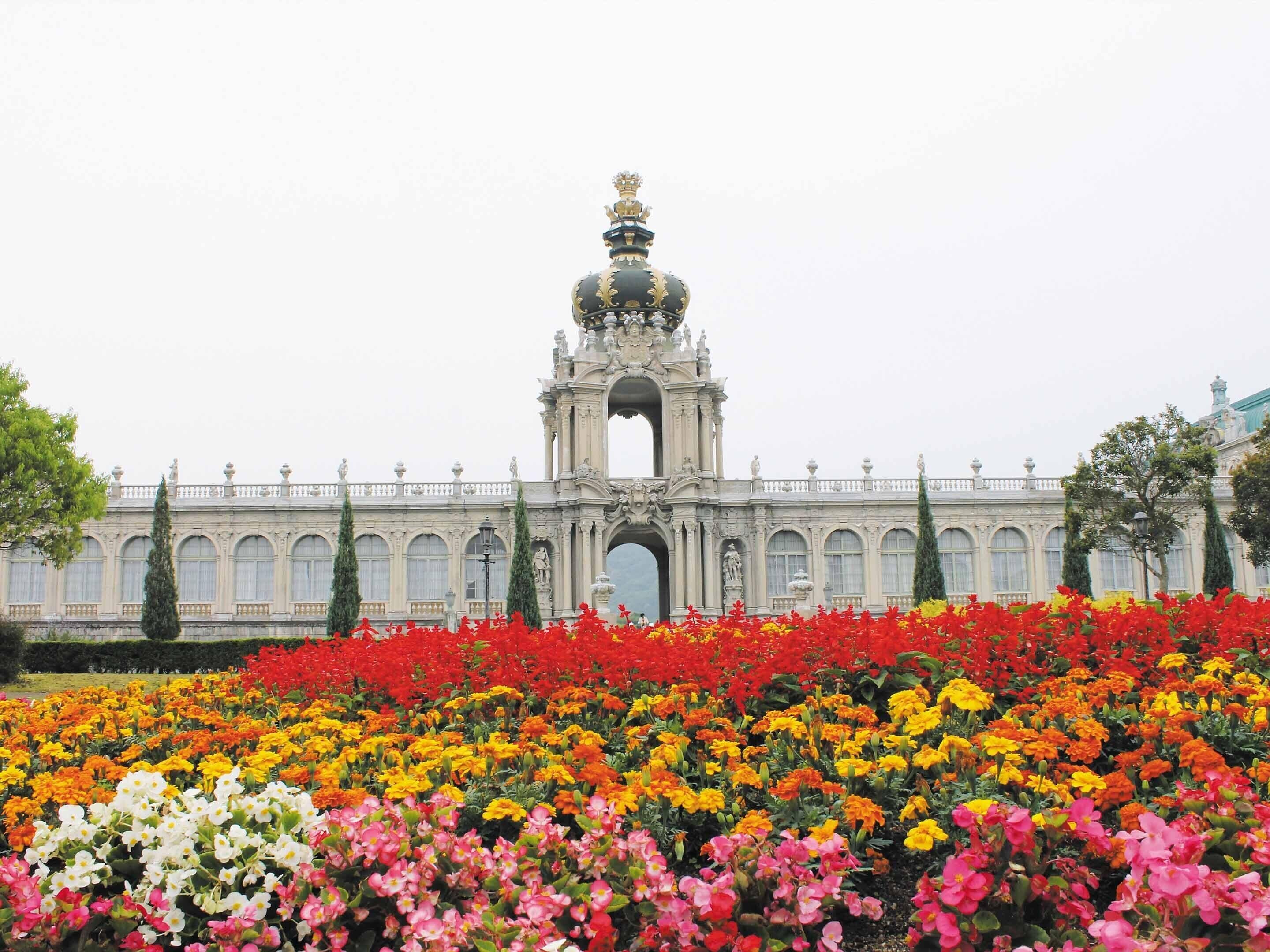 A grand building with a central archway and a statue on top.