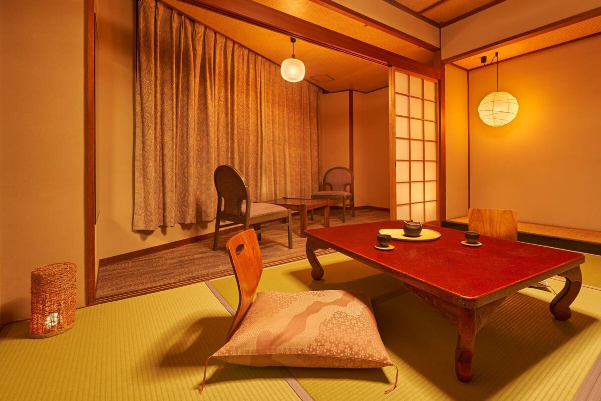A traditional Japanese room with tatami flooring, a low table, and shoji screens.
