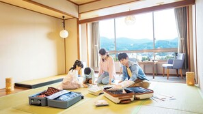 A tatami mat room with a large window, a hanging light fixture, and a view of distant mountains. - Ooedo Onsen Monogatari Ureshinokan (Ureshino)