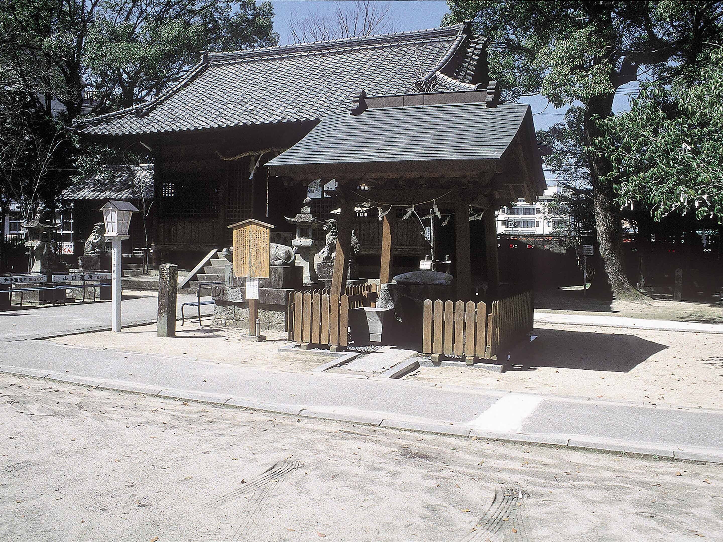 A traditional Japanese building with a tiled roof and a wooden structure in front.