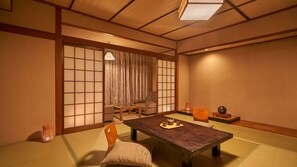 A traditional Japanese-style room with tatami flooring, a low table, chairs, and sliding doors. - Ooedo Onsen Monogatari Ureshinokan (Ureshino)