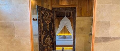 A bathroom with a large mirror, a white sink, and a wooden vanity.