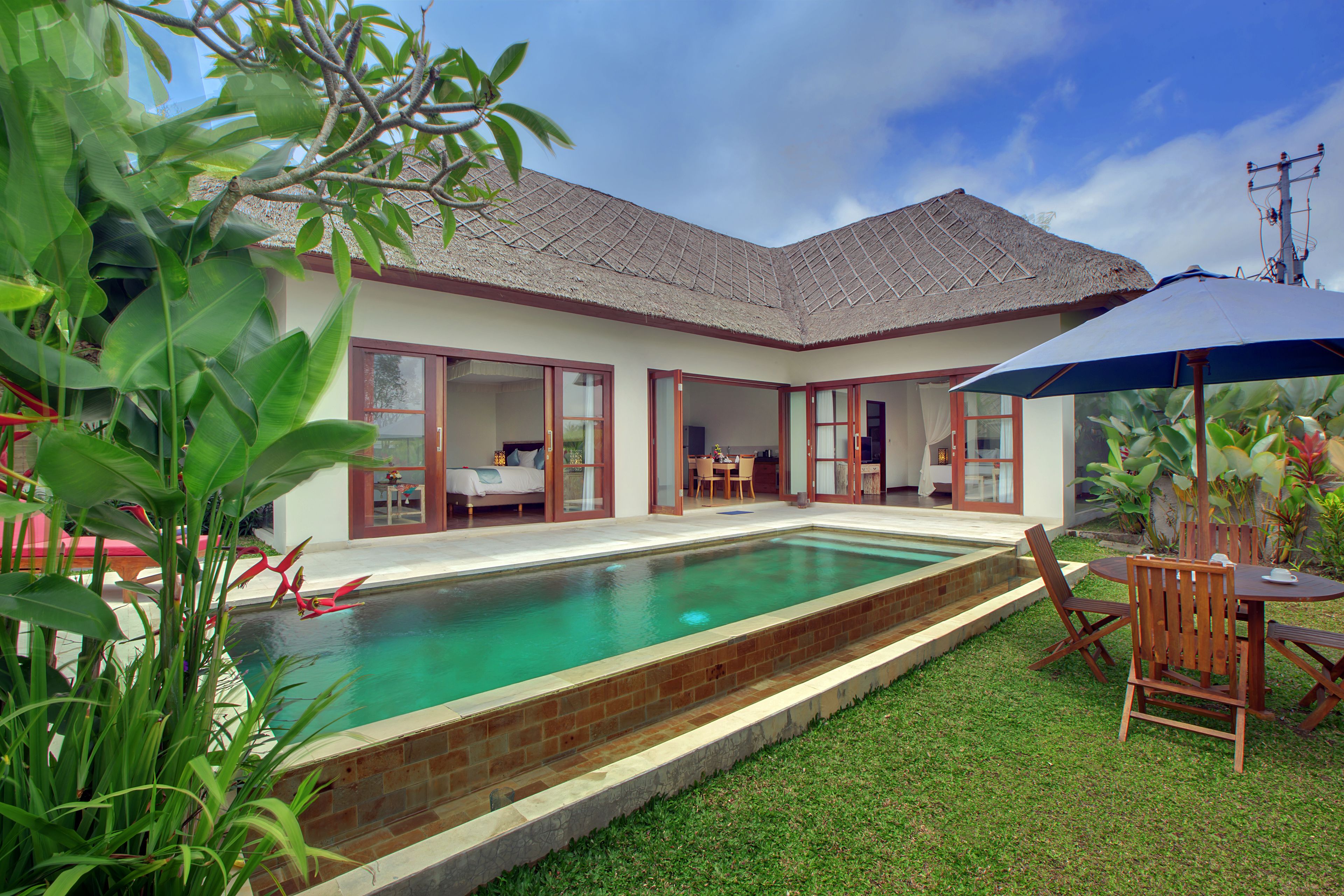 Ein Haus mit Pool, Essbereich und überdachter Terrasse.