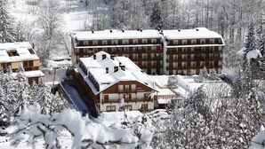 A hotel with multiple buildings, snow-covered trees, and a clear view of the surrounding landscape. - Club Hotel Solaris (Cesana Torinese)