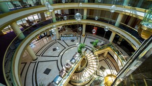 A multi-level atrium with a central spiral staircase, glass railings, and hanging spherical light fixtures. - Alder Resort Hotel - Ultra All Inclusive (Kemer)
