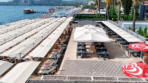 A beachside restaurant with outdoor seating, umbrellas, and a view of the sea. - Alder Resort Hotel - Ultra All Inclusive (Kemer)