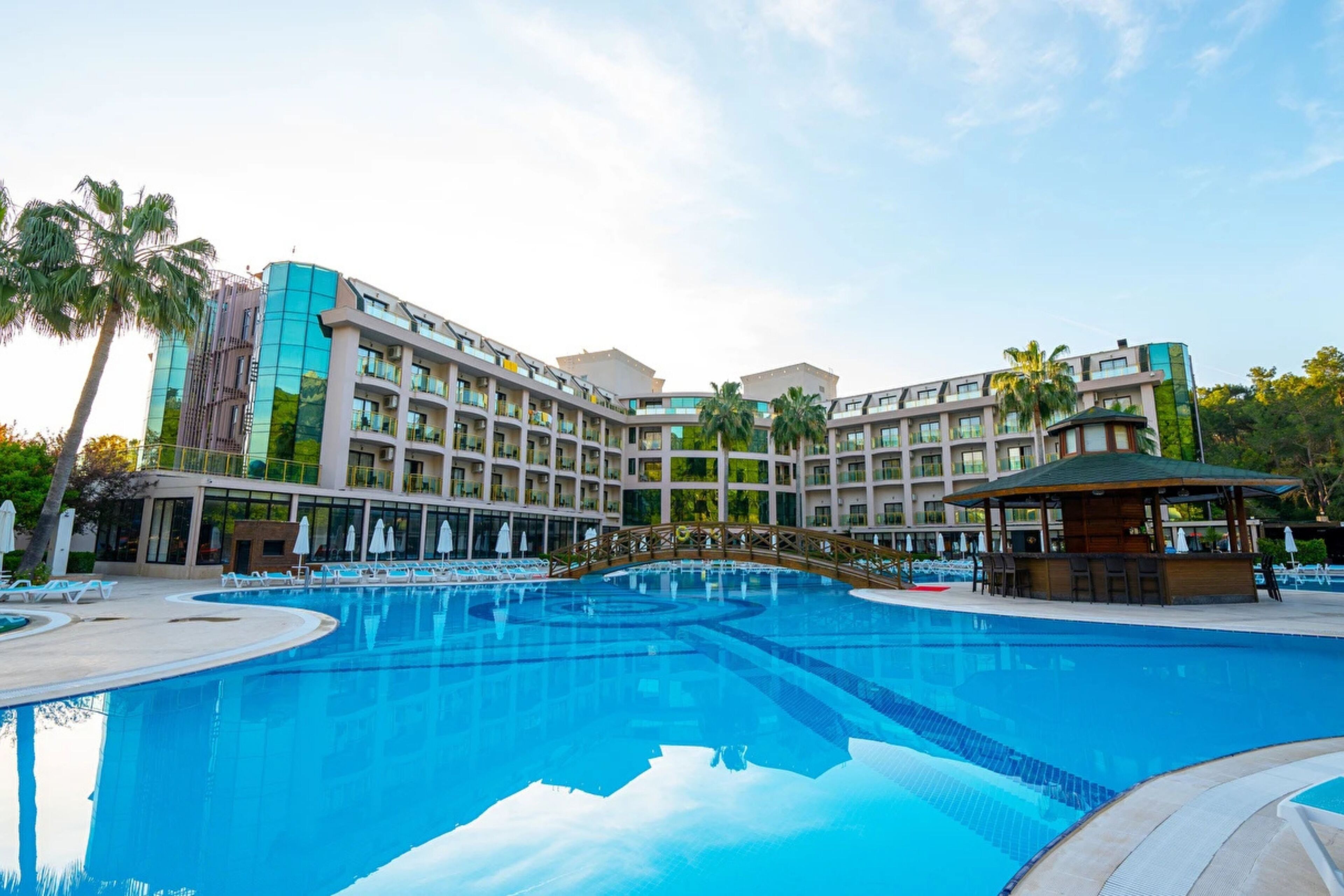 Um hotel com uma piscina grande, várias varandas e um design arquitetônico moderno.