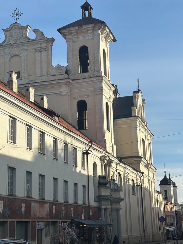 A historic building with a bell tower and arched windows. - Bookinn B&B (Vilnius)