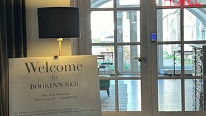 A welcome sign for BOOKINN B&B with a view of the hotel entrance and a door labeled "HOTEL". - Bookinn B&B (Vilnius)