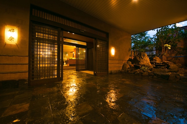 A traditional Japanese entrance with wooden gates and stone flooring.