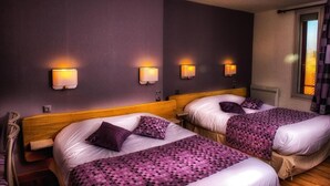 A hotel room with two beds, each with a headboard, a window with curtains, and wall-mounted lights.