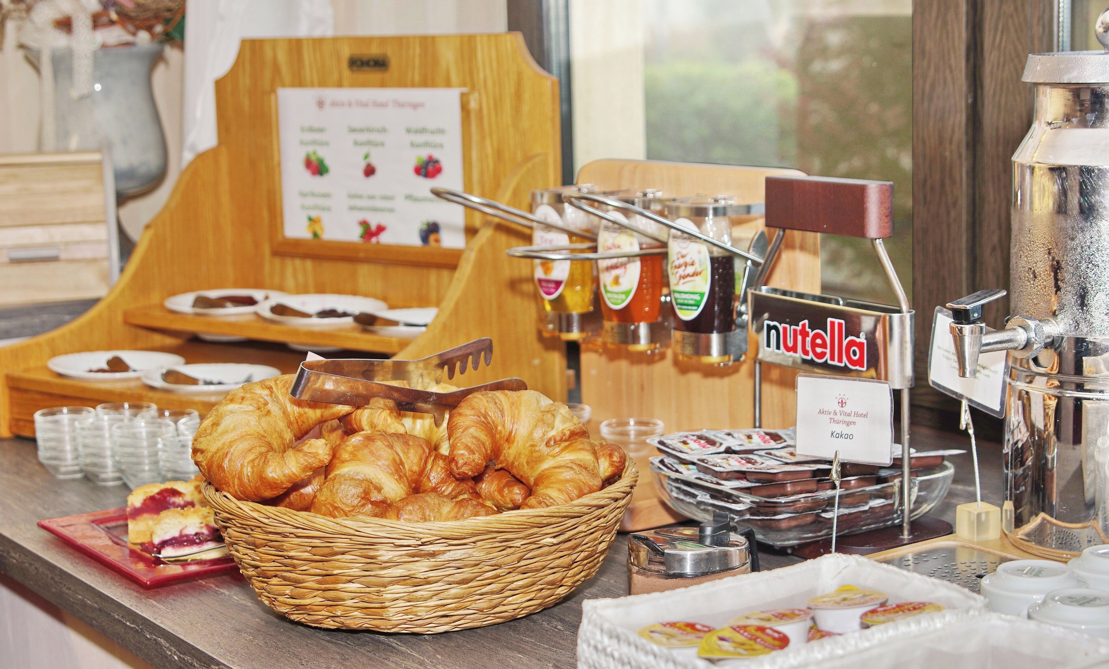 A breakfast buffet with croissants, Nutella, and other spreads.