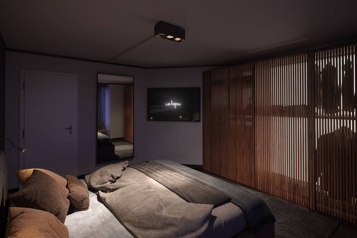 A modern bedroom with a bed, a TV, and a sliding wooden door.