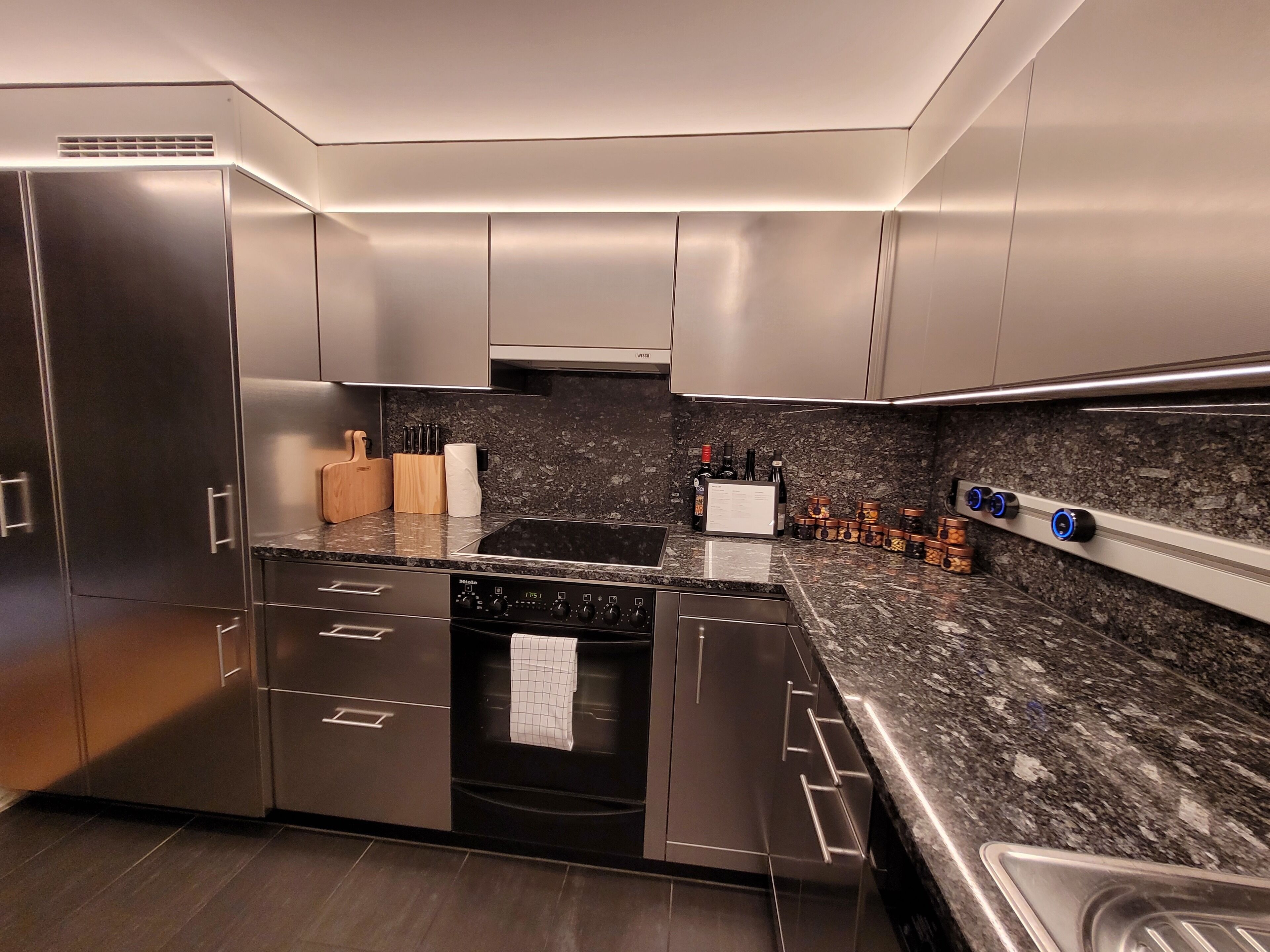 A modern kitchen with stainless steel appliances, a granite countertop, and a built-in oven.