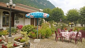 A patio area with outdoor seating, potted plants, and a mountain backdrop.