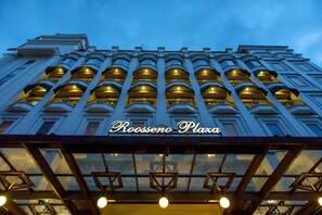 Un edificio alto con una entrada destacada y varios balcones.