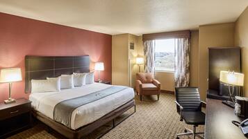 Una camera d'albergo con un letto, una scrivania, una sedia e una televisione.