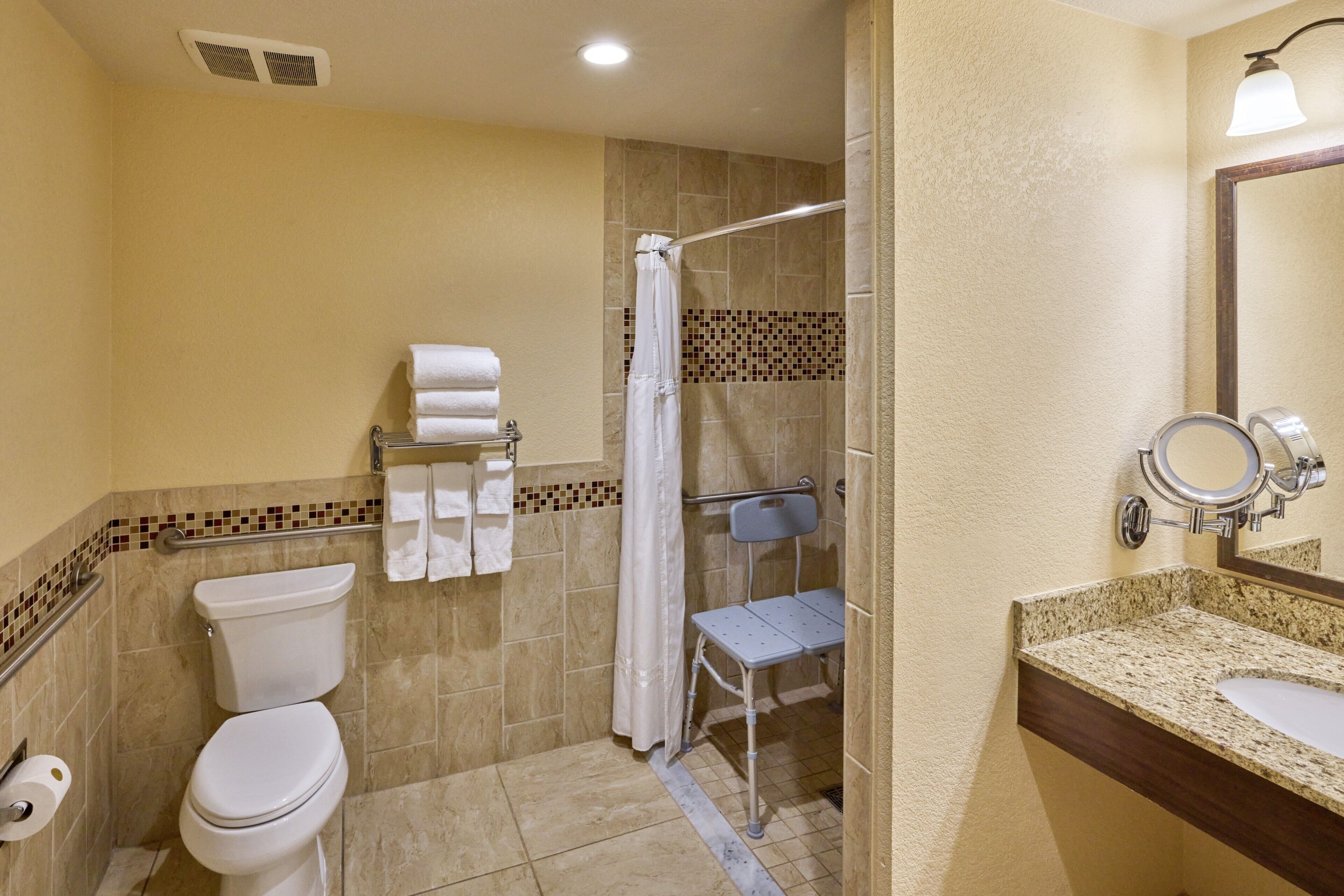 A bathroom with a toilet, shower, and sink.