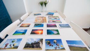 A conference table with various printed materials, including brochures and photographs of landscapes and hot air balloons. - Fu Taitung B&B (Taitung)