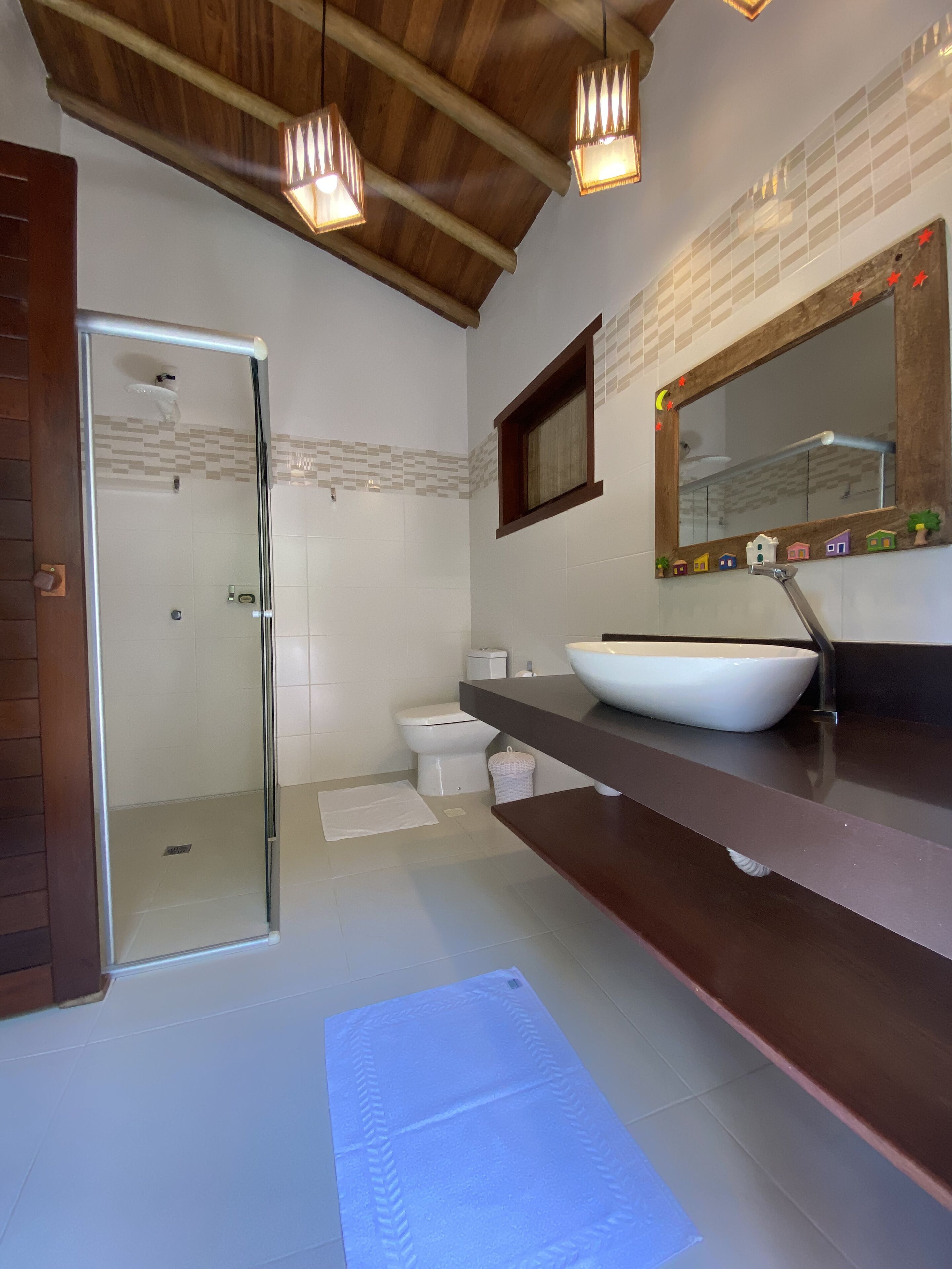 A modern bathroom with a glass-enclosed shower, a white toilet, and a large vessel sink.