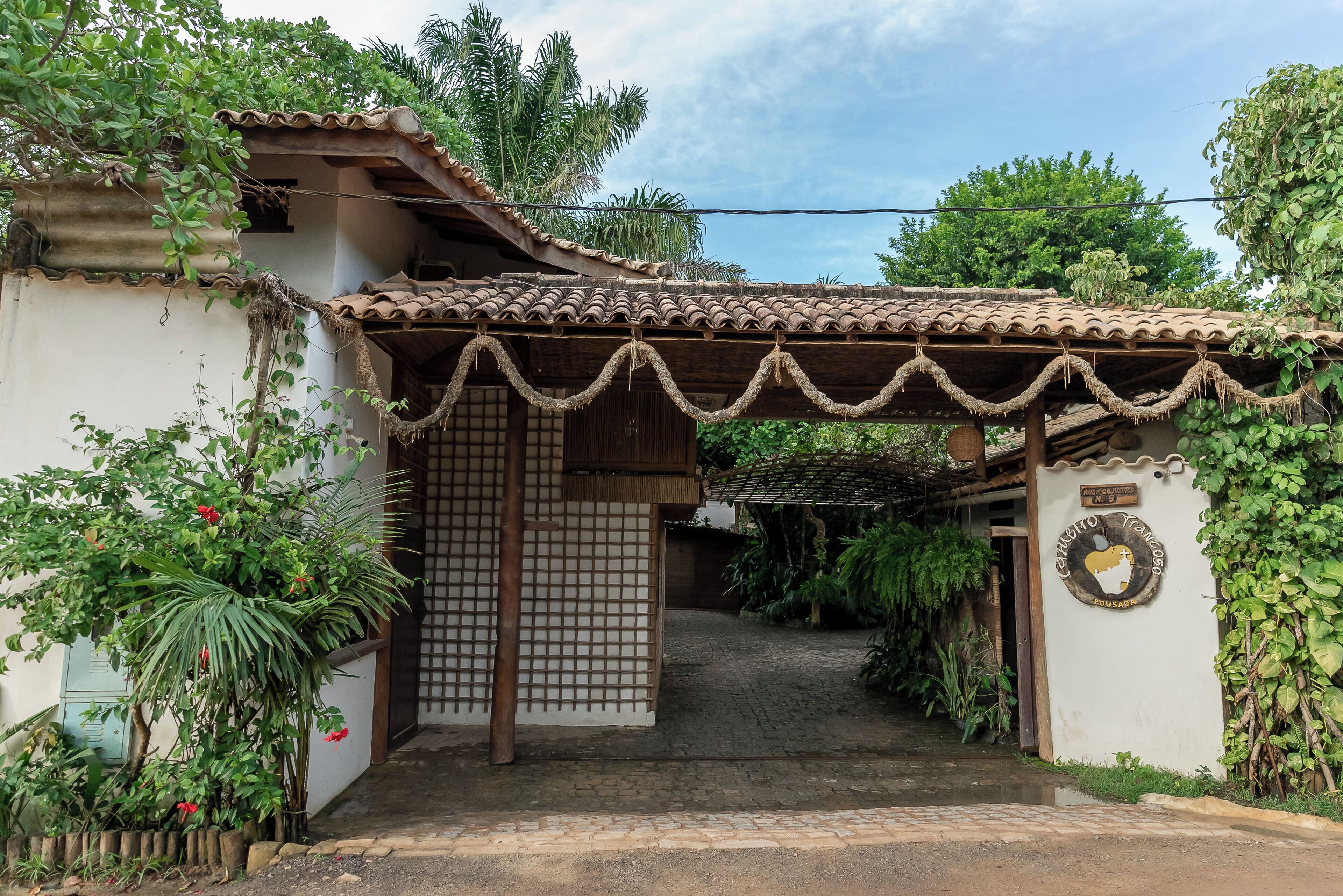 Une maison traditionnelle avec un toit en tuiles, une porte en bois et une enseigne.