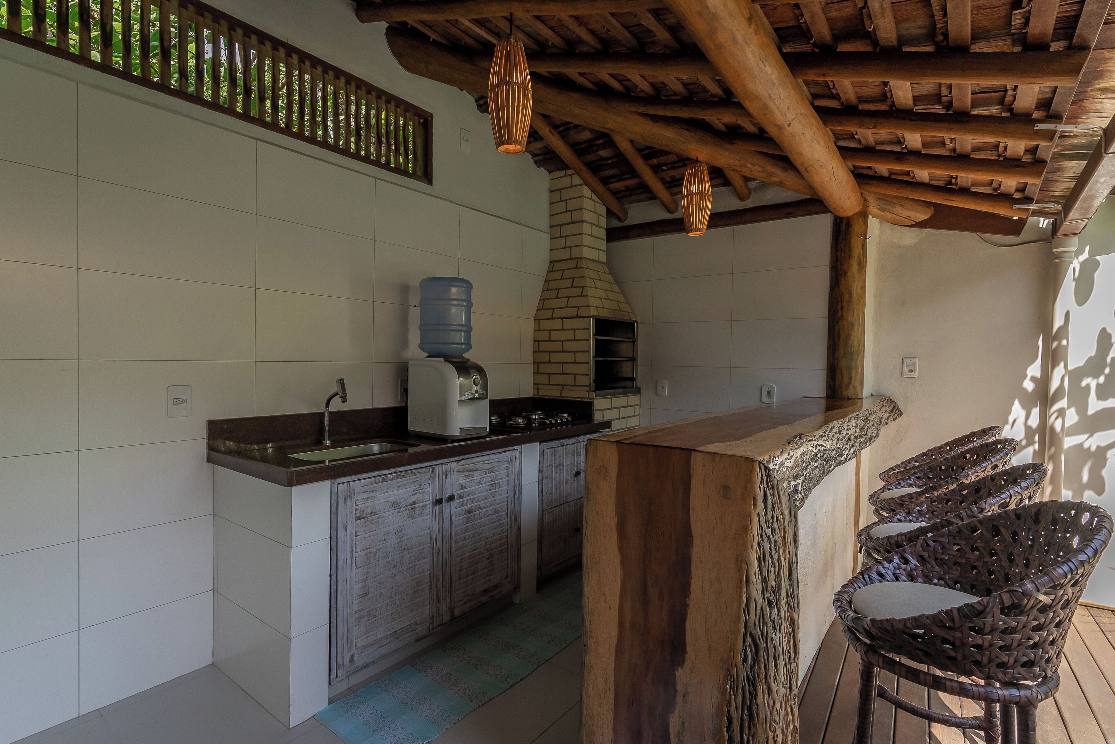 A kitchen with a wooden island, a water dispenser, and a brick oven.